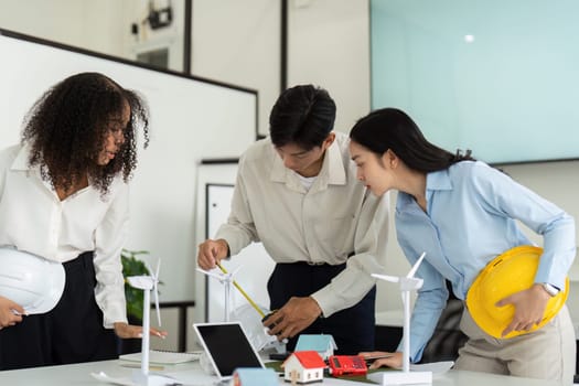 Three engaged professionals focus on developing eco-friendly engineering strategies, utilizing innovative tools and ideas in their sustainable project discussions.