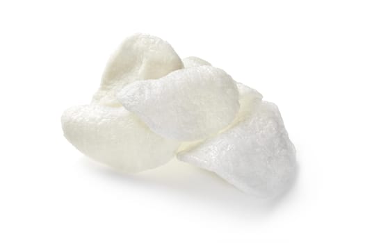 Crunchy prawn crackers, also known as shrimp chips, creating a small pile on a clean white background