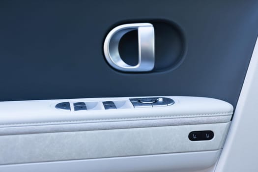 Control buttons for settings and memory of the driver's seat, electric glass opening, door handle in the interior of the new luxury electric car. Driver's seat adjustment buttons.
