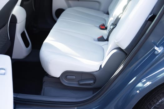 Rear leather passenger seats in modern lux electric car. Leather car passenger seat. Control unit with electric seat adjustment media system for rear passengers in luxury car. Car interior detail.