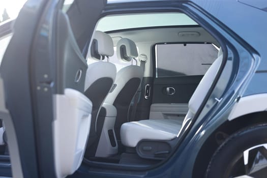 Hatch in car roof. Panoramic glass sun roof in the car. Clean glass and view from inside to the sky. Double sunroof hatch with tinted glass. Rear leather passenger seats in modern lux electric car.