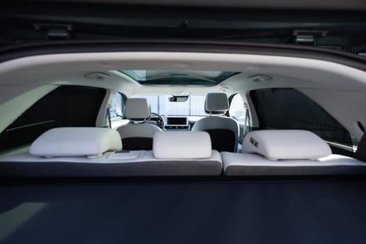 Panoramic glass sun roof in the modern car. Clean sunroof and view at the sky from the inside or car interior. The view from the empty car trunk with rear seats.