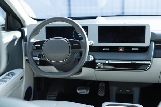 Electric car interior luxury. Interior of prestige modern car. Leather comfortable seats, dashboard and steering wheel. Cockpit with exclusive decoration.