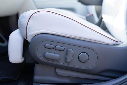 Driver's seat adjustment buttons. Buttons for adjusting seat position. Car interior. Furniture Adjustment Button Activated Power Seat Expensive White Leather.