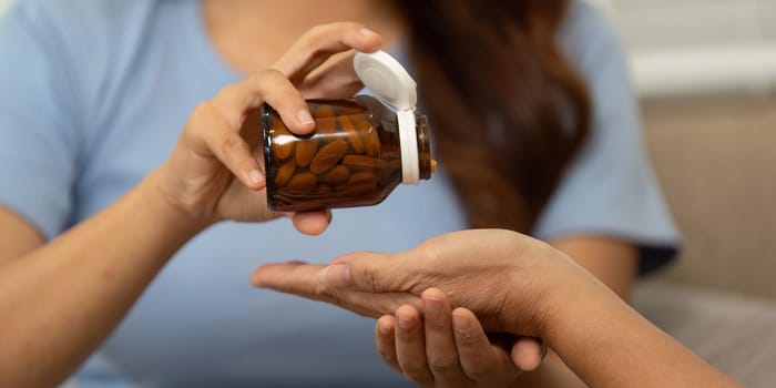 In a nurturing exchange, a mother gives her child vitamins from a jar, highlighting the importance of sharing health knowledge and the essence of care.