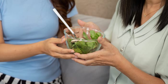 A loving mother and her child share a bowl of fresh greens, emphasizing the importance of nutrition and wellness in their daily lives. Moments like these foster bonding and healthy habits.