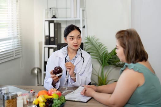 In an ergonomic setting, a nutritionist discusses important dietary principles while showcasing fresh fruits and vegetables.