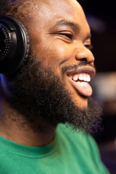 Happy enthusiastic sound designer feeling cheerful composing music, doing what he loves in his home studio. Positive smiling musician producing new soundtracks with stereo gear. Close up.