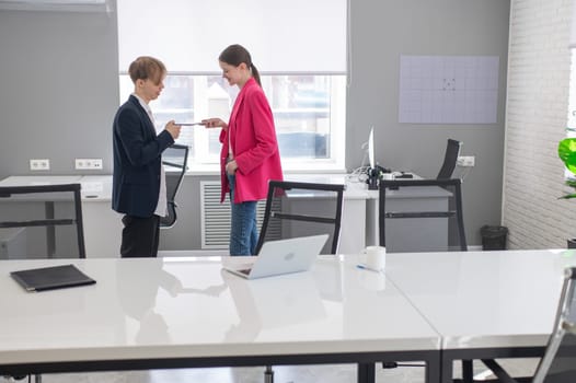 Colleagues use smartphones at work in the office