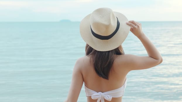 Beautiful Asian woman holding rubber ring running on the beach, Happy female in bikini having fun on tropical beach vacation getaway travel holiday destination, relaxing feeling free in summer holiday