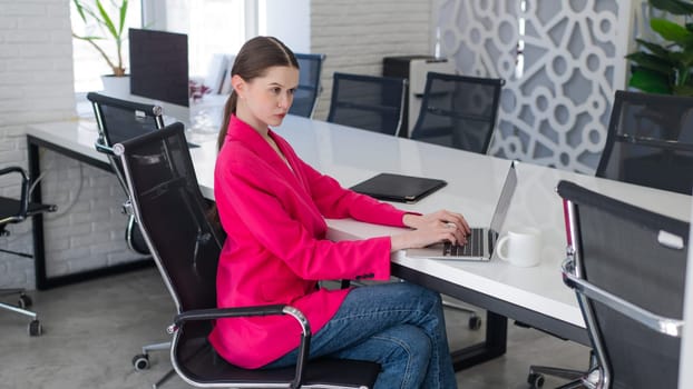 Caucasian woman typing on laptop at work