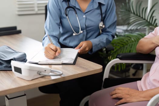 A doctor carefully records vital signs and health details during a routine consultation, prioritizing the patient's wellness and care.