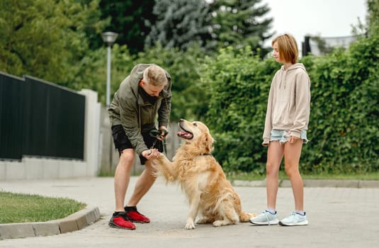 Golden Retriever Gives Paw To Owner Who, With Daughter, Went For A Summer Walk