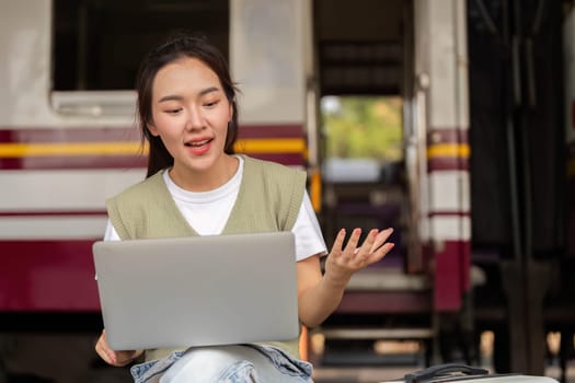 Amid the hustle of a train station, a young woman captures her excitement during a video call, showcasing the blend of travel and technology.