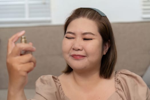 Enveloping her face in a refreshing mist, a woman experiences a moment of tranquility, highlighting the importance of self-care in her daily beauty rituals.