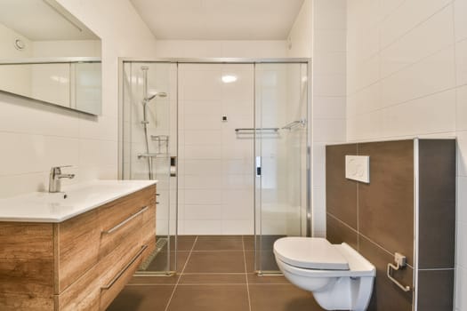A stylish and contemporary bathroom featuring a glass shower, wooden vanity, and sleek fixtures, showcasing functionality and elegance.