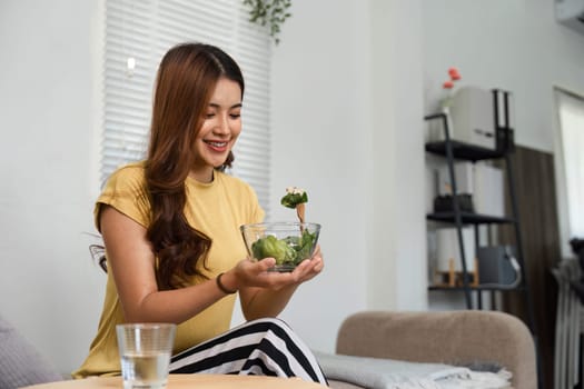 As part of her morning ritual, the woman enjoys a refreshing salad, illustrating her commitment to healthy living and self-care.
