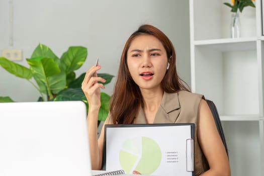 In a contemporary workspace, a young professional uses video conferencing to share her analytical insights, gesturing toward a pie chart to illustrate her key points.
