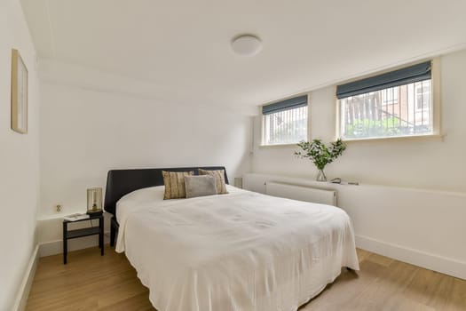A serene and simple bedroom showcasing a comfortable bed, stylish decor, and natural light filtering through the windows.