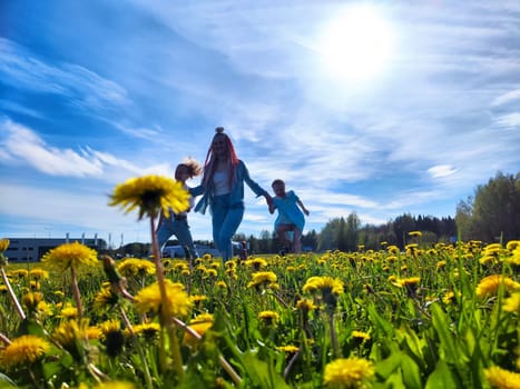 A group of children happily run through a vibrant field filled with dandelions on a sunny afternoon.