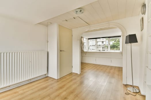 A bright and airy minimalist interior space showcasing wooden flooring, large windows, and simple furnishings. Perfect for modern living aesthetics.