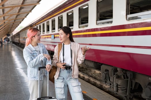 Two travelers stand by the train, animatedly discussing their trip, emphasizing friendship and the joy of shared experiences during travel.