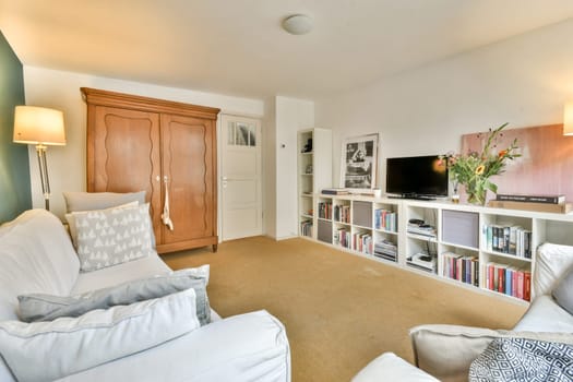 A stylish living room featuring a comfortable sofa, wooden furniture, and decorative elements that create a warm atmosphere. Perfect for relaxation and entertainment.