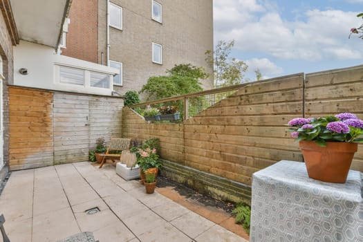 An inviting outdoor area featuring wooden fences, potted plants, and tiled flooring, perfect for relaxation and enjoying nature.