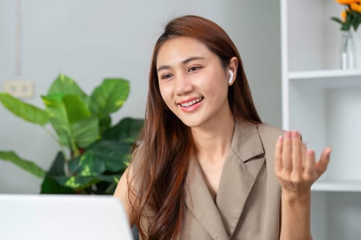 During a lively video call, a young professional connects with her team, sharing insights while showcasing a friendly demeanor and encouraging interaction.