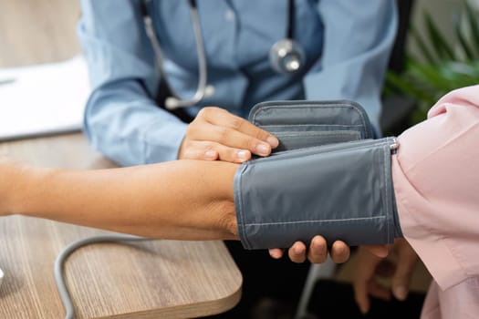 A nurse conducts a blood pressure check on a patients arm in a warm and supportive healthcare environment, emphasizing the importance of regular health monitoring.