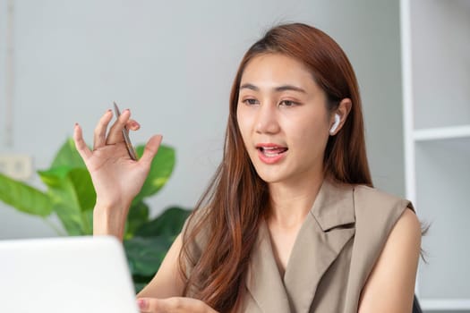 In a modern workspace, a professional woman expresses her ideas with clarity and confidence during a video meeting, highlighting her key points with gestures.