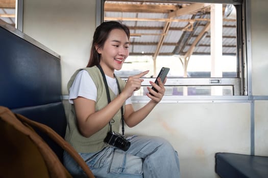 Seated comfortably in the train, she interacts with her phone, sharing her journey with friends online.