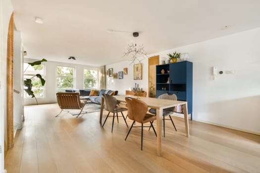 A bright and airy room featuring stylish furniture, large windows, and wooden flooring, perfect for contemporary living spaces. An inviting atmosphere exudes relaxation.