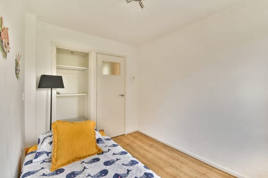 A bright and airy minimalist bedroom featuring a wooden floor, simple decor, and a touch of color with a yellow throw pillow, creating a serene atmosphere.
