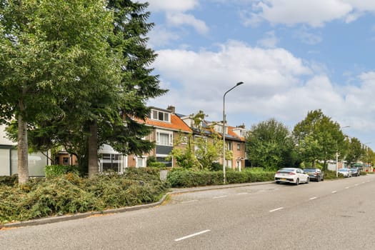 A picturesque residential street lined with vibrant greenery and quaint houses under a clear sky, highlighting a tranquil suburban environment.