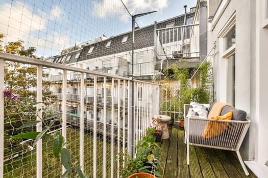 A beautifully designed balcony featuring modern furniture and vibrant green plants, creating a perfect outdoor relaxation space.