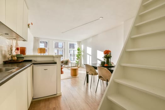 A modern kitchen featuring sleek cabinetry, a minimalist design, and natural light showcasing a stylish dining area and decorative plants.