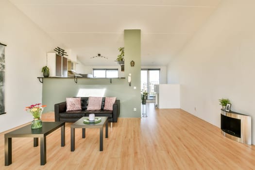A spacious and modern living room featuring a minimalist aesthetic with natural light, stylish furniture, and decorative elements. The design emphasizes simplicity and comfort.