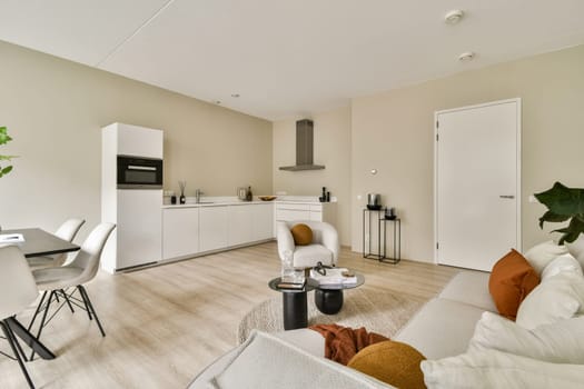 This modern living room showcases a sleek design with neutral tones, stylish furniture, and vibrant greenery, creating a serene and inviting atmosphere.