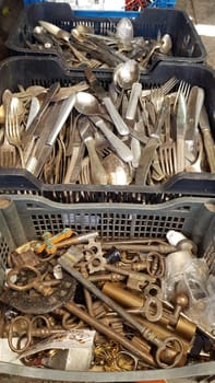 Selective focus vintage keys and cutlery inside old boxes at flea market in Athens. Garage sale of antique items