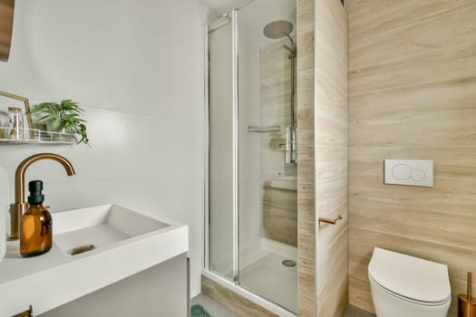 Stylish modern bathroom featuring a glass shower, sleek sink with a decorative bottle, and contemporary fixtures, blending functionality with elegance.