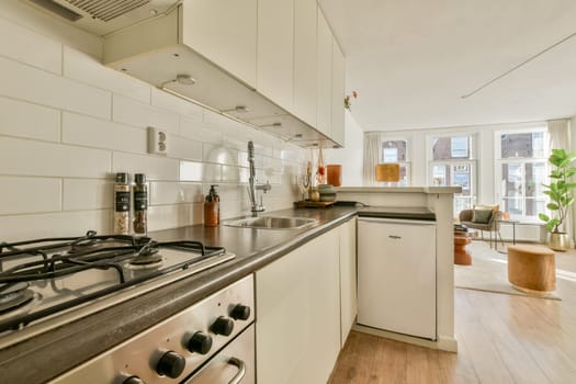 A bright modern kitchen featuring sleek cabinetry, stainless steel appliances, and a cozy seating area flooded with natural light from large windows.