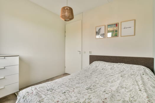 A serene and stylish bedroom featuring a white bedspread, minimalist decor, and natural light enhancing the ambience. Ideal for relaxation and comfort.