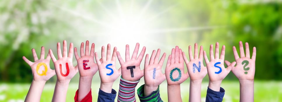 Children Hands Building Colorful English Word Questions. Summer, Sunny Green Grass Meadow As Background