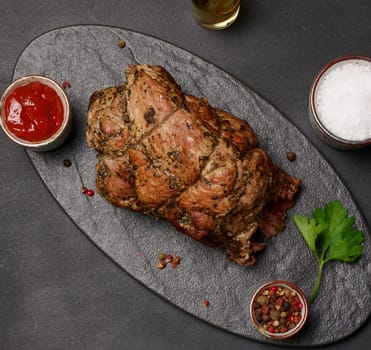 Baked pork collar with spices on a wooden board, delicious and juicy meat