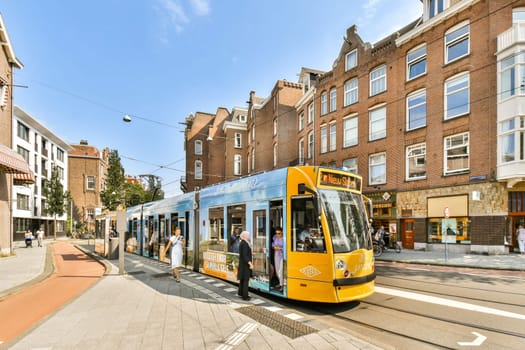 A vibrant tram making its way through a bustling city street lined with historic buildings, showcasing daily urban life and transport.