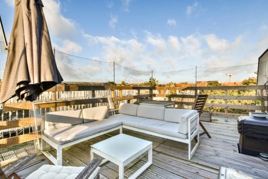 A stylish outdoor patio featuring contemporary seating arrangements, a white table, and an inviting atmosphere, perfect for relaxation and gatherings.
