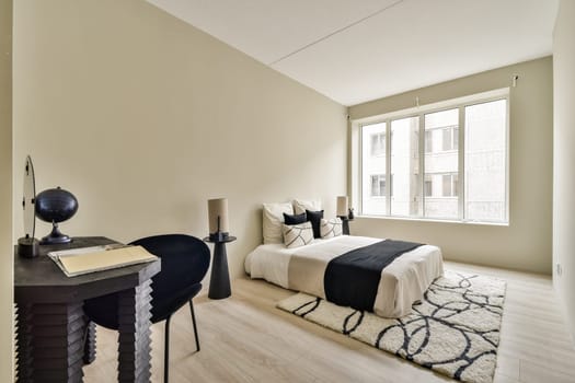 A sleek and modern bedroom featuring soft colors, minimal furniture, and large windows that bring in natural light, creating a cozy atmosphere.