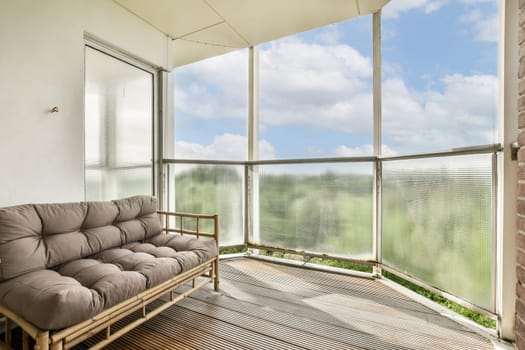 A serene balcony featuring comfortable seating and expansive views of greenery under a bright sky. Ideal space for relaxation and enjoying nature.