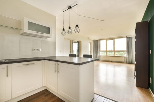 A stylish kitchen featuring sleek cabinetry, contemporary lighting, and an open layout that merges functionality with aesthetics, showcasing an inviting atmosphere.
